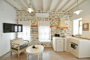 a kitchen with a living room with a couch and a table at Psaropoula Guest House in Hydra