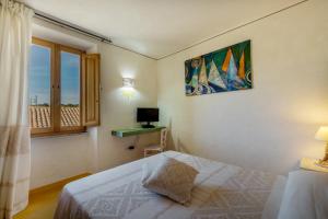 a bedroom with a bed and a desk and a window at palazzo beddoro charming apartments in San Pantaleo