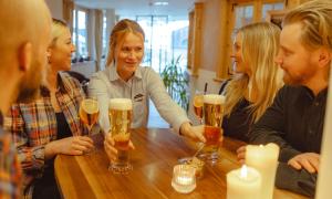 a group of people sitting around a table drinking beer at Hotel Abendrot by Alpeffect Hotels in Ischgl +15 photos