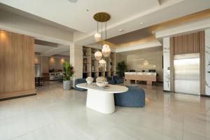 a lobby with a white table and blue chairs at Hotel Anselmo in Boca Chica