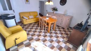 a living room with a yellow couch and a table at La madeleine in Malandry +10 photos