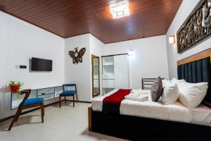 a bedroom with a bed and a desk and a television at Golden stars hotel Dambulla in Dambulla
