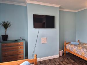 a bedroom with a bed and a tv on the wall at Tommy Two-Threes in Pill