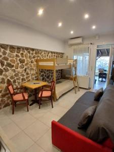 a living room with a couch and a bed and a table at Kohyli Apartments in Skala Rachoniou