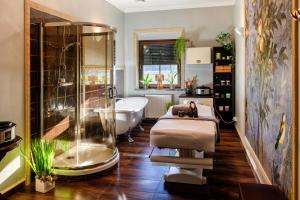 a bathroom with a bath tub and a claw foot bath tub at Na Kamieniu Hotel & Spa in Olesno