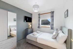 a bedroom with a bed and a mirror at Harbour Views in Ferryden
