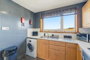 a kitchen with a sink and a washing machine at Harbour Views in Ferryden +12 photos