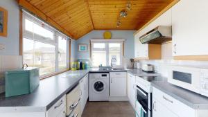 a kitchen with white appliances and a wooden ceiling at C29 Regwin, Riviere Towans in Hayle +10 photos