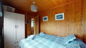 a bedroom with a bed in a wooden wall at C29 Regwin, Riviere Towans in Hayle