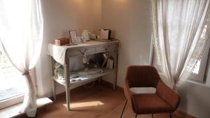 a chair and a table in a room with a window at Mas des Treilles - Chambre d'hôtes "Côté Villages" in Mane