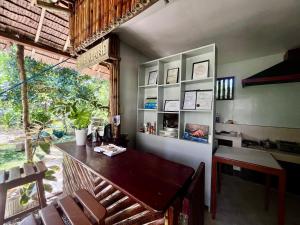 a dining room with a table and chairs and a window at Babaland in New Agutaya