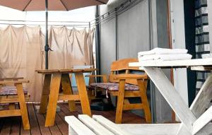 a balcony with wooden tables and chairs and an umbrella at Stunning Home In Rybical With Wifi in Rybical