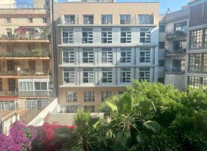 a tall apartment building with trees in front of it at Central Urban Elegance in Barcelona