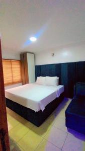 ein Schlafzimmer mit einem großen Bett und einem Stuhl in der Unterkunft Plot1 Suits in Ibadan
