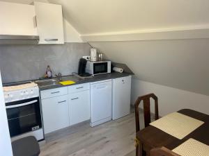 a small kitchen with white appliances and a table at Aux cigogneaux in Guémar