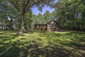 a house in the middle of a field with a tree at Peaceful Kannapolis Lodge in Kannapolis
