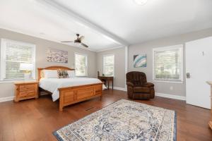 a bedroom with a bed and a chair and windows at Peaceful Kannapolis Lodge in Kannapolis