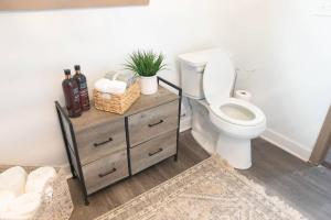 a bathroom with a toilet and a wooden dresser at ASecondU Peaceful Retreat in Salisbury