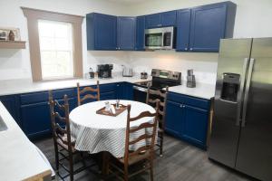 a kitchen with blue cabinets and a table with a white table cloth at ASecondU Peaceful Retreat in Salisbury