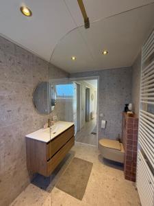 a bathroom with a sink and a tub and a toilet at Vakantiewoning De Bosrand Aan Zee in Sint Annaland +26 photos