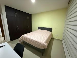 a small bedroom with a bed and a table and chairs at Modern and Cozy Home in Acayuca +11 photos