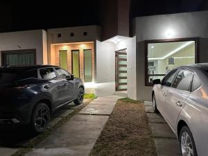 two cars parked in front of a house at night at Modern and Cozy Home in Acayuca