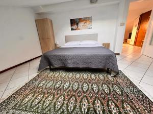 a bedroom with a bed and a rug on the floor at Casa LOUES in Asti