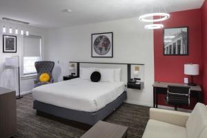 a hotel room with a white bed and a red wall at Ramada by Wyndham Jersey City in Jersey City