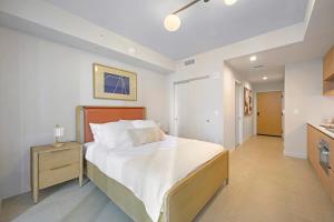 a bedroom with a large bed and a kitchen at Prime Location Studio Steps from Top Attractions in Miami