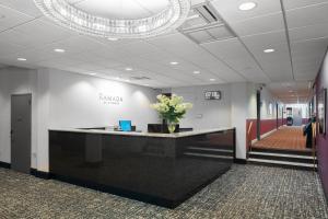 a lobby with a reception desk with flowers on it at Ramada by Wyndham Jersey City in Jersey City