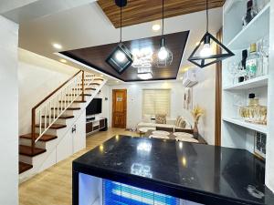 a kitchen and living room with a black counter top at Casa Terrazza Marteja in Malolos