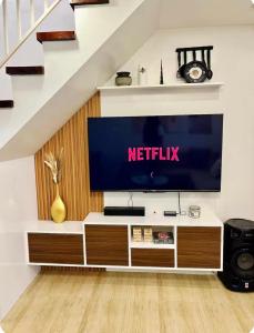 a living room with a television on a tv stand at Casa Terrazza Marteja in Malolos