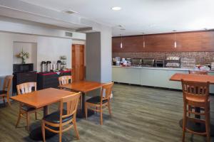 a restaurant with wooden tables and chairs and a kitchen at Ramada by Wyndham Jersey City in Jersey City