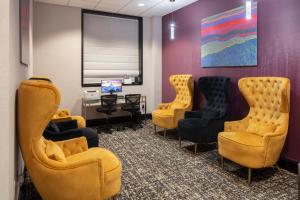 a waiting room with chairs and a desk and a computer at Ramada by Wyndham Jersey City in Jersey City