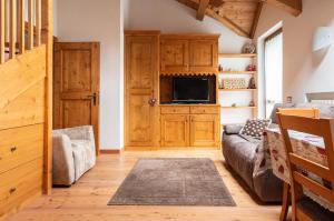 a living room with a couch and a tv at Accogliente mansarda con vista Dolomiti in Borca di Cadore