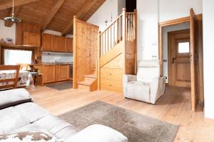 a living room with a couch and a stairway at Accogliente mansarda con vista Dolomiti in Borca di Cadore