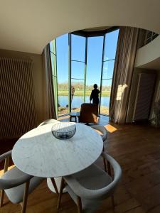 a white table and chairs in a room with a view at Villa Francine in Deinze
