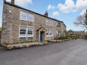 a brick building with a blue door on a street at Kirk Yett in Skipton