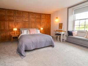 a bedroom with a bed and a desk and a window at Kirk Yett in Skipton