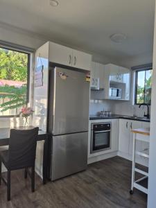 a kitchen with a stainless steel refrigerator and a table at Convenient Getaway Home in Strathpine in Strathpine