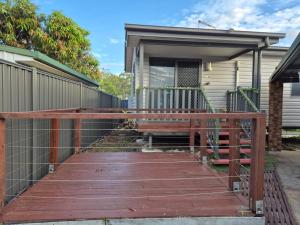 a wooden walkway leading to a house with a bench at Convenient Getaway Home in Strathpine in Strathpine