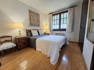 a bedroom with a bed and a chair and a window at Llívia Sky Valley in Llivia