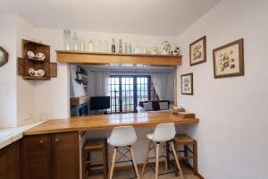 a kitchen with a wooden counter and stools at Llívia Sky Valley in Llivia