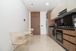 a kitchen with a table and a chair in it at Bright Cozy Escape Walk to CFC Self Check-in in Oulad Akkou