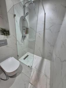 a white bathroom with a shower with a toilet at Bright Cozy Escape Walk to CFC Self Check-in in Oulad Akkou