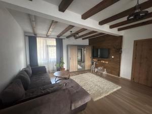 a living room with a couch and a table at Панорамна гледка in Leshten