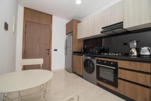 a kitchen with a table and a stove and a sink at Bright Cozy Escape Walk to CFC Self Check-in in Oulad Akkou