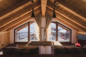 a bedroom with a bed and a large window at Hôtel Daria-I Nor by Les Etincelles in L'Alpe-d'Huez
