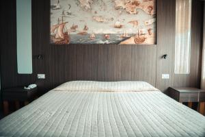 a bedroom with a bed with a painting on the wall at Hotel Ulisse in Marina Romea +63 photos
