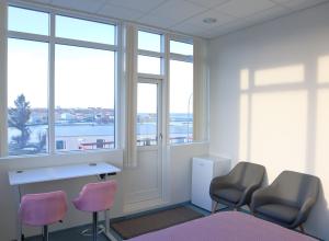 a room with three chairs and a desk and windows at Gistiheimilið Ósbær in Blönduós